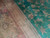 Detail of ivory guard stripes meeting the green field with scrolling vines and rosettes