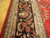 Border detail with red rosettes, rust leaves and pale blue guard stripes on black ground
