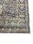 Corner of the Indian Oushak rug where the animal filled field meets deep green border