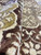 Side lit texture shot highlighting gold medallion outlines and the low even pile height