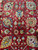 Detailed wool pile texture with multicolored palmettes, boteh cones and blossoms on a deep red ground