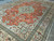 Angled view showing coral field, ivory border and dense hand-knotted wool pile of Tabriz rug