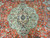 Close-up of green lobed medallion with navy centre rosette and grazing deer on coral ground