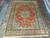 9' x 12'7" Persian Tabriz rug photographed from above on grey tile, coral and ivory palette