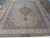 Hand-knotted wool and silk Tabriz rug laid flat, ivory field with navy and teal accents