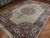 Angled view of large 10x14 wool and silk Tabriz rug showing rose main border