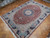 Angled view of rust field, ivory spandrels and navy guard bands on 10x13 Tabriz