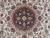Close-up of navy lobed medallion with rose palmettes and ivory vine scrollwork in fine Persian weaving