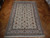 Ivory wool and silk Tabriz rug on parquet floor showing dense floral vinework and tan borders