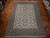 Ivory and tan Isfahan rug laid flat on parquet floor showing balanced all-over floral field