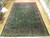 12 x 18 Persian Tabriz rug laid flat on parquet showroom floor, full tree of life field visible