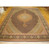 Full view of 11'6" x 16'8" Persian Tabriz rug with black Mahi field on parquet floor
