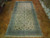 10'1" x 19'8" Persian Kashan rug laid on parquet flooring showing ivory field and blue border