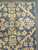 Corner close-up with beige fringe, tight selvage and crisp hand-knotted blossom motifs on blue