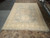 10'5" x 14'10" Khotan Oriental rug laid flat on showroom floor showing triple medallion layout