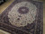 Angled view showing dense floral field, navy corner spandrels and triple border of hand-knotted rug