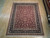 7'10" x 9'8" Chinese Oriental rug displayed flat on light hardwood showroom flooring