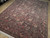 8x10 traditional wool rug angled view showing dense all-over floral field and layered borders