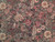 Close-up of cream peonies, raspberry roses and sage leaves on mocha brown wool field
