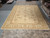 12' x 15'4" oversize Chobi rug laid flat in the Rugs.net warehouse beside stacked inventory