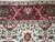 Burgundy main border with ivory vine scroll, green palmettes and turquoise accents in dense wool