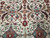 Ivory field detail with burgundy lattice, teal blossoms and serrated brown leaves, hand-knotted wool
