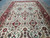 Angled full-length view of the 9' x 18' oversize wool rug on grey tile floor