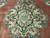 Close-up of the black-ground central medallion with celadon green leaves and coral rosettes