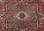 Close-up of the stepped geometric medallion in navy, ivory and terracotta wool on red ground