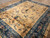 Angled view of the camel field, flowering branches and blue multi-border on this antique Chinese rug