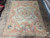 Dusty rose Aubusson rug shown on stone floor with scalloped ivory field and corner medallions