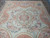 Ivory field with rosette medallion, rose wreath and pink ribbons on this 9x12 flat weave rug