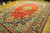 Angled showroom view of palace size red Sarouk rug with teal, salmon and ivory spandrels