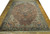 Angled floor view of antique Persian village rug, terracotta ground with stepped geometric medallion