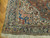 Corner detail showing ivory spandrel, navy floral border and hand-tied cream fringe ends