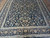 Lower half of the rug with layered ivory and navy guard borders framing floral field