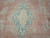 Detail of the medallion core, cream center and blue palmette outline over dusty pink wool