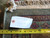 Back of the rug with inventory tag F-5947, cotton fringe and tape measure for scale