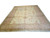 Angled studio view of ivory and shrimp Oushak rug showing full floral field and border