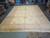 Overhead warehouse shot showing ivory field, salmon border and sage vinework across the entire rug