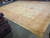 Room scale perspective showing the pink border sweeping along one long side of the rug