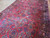 Deep raspberry red ground with indigo palmettes, cypress sprays and a wide navy floral border