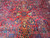 Gold and ivory leaf motifs surrounding a small navy cruciform motif at rug center