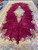 Angled view of oversize burgundy Kerman rug showing scalloped ivory spandrels and blue floral main border