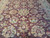 Detail of the central sage rosette medallion surrounded by scrolling vines on deep burgundy ground