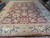 Wide view of burgundy Chobi rug border, guard borders and ivory fringe on tile floor
