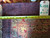 Back of the 14'3" x 19'6" rug with tape measure showing hand-knotted density and tag