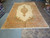 Palace size Kerman rug displayed beside rolled inventory in the Freeport New York rug warehouse