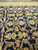 Vertical detail of navy field with gold palmettes, leafy vines and ivory outer border
