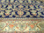 End border detail with lotus blossoms in salmon and ivory against the navy ground